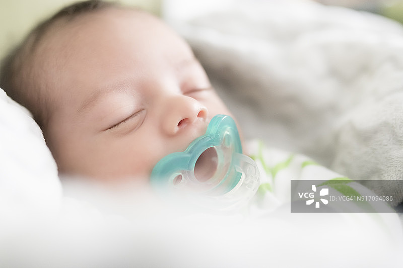 含着奶嘴熟睡的新生婴儿图片素材