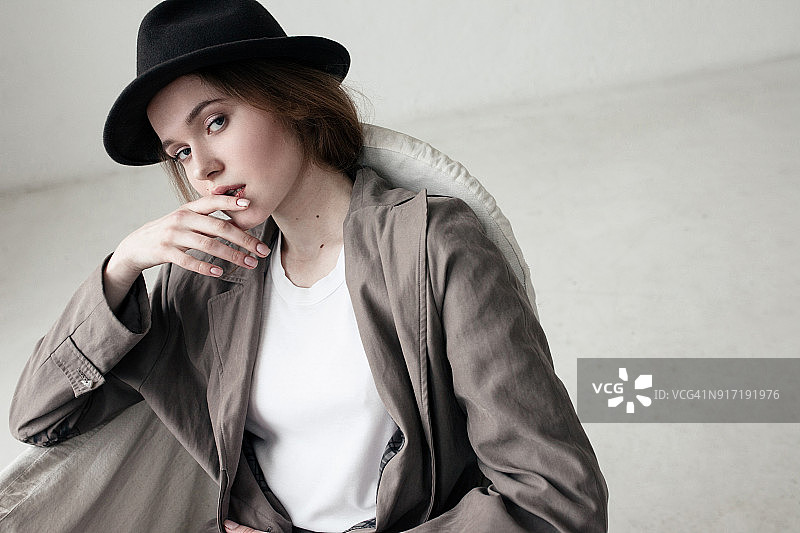 影棚拍摄：一位有魅力的女士用手指放在嘴里图片素材