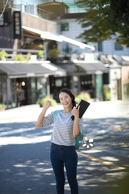 户外手捧书本的快乐学生图片素材