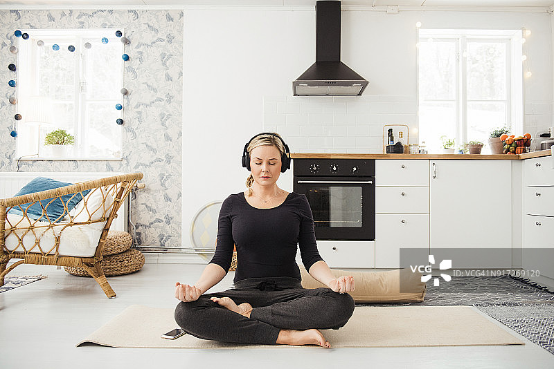 在厨房做瑜伽和冥想的真实女人图片素材