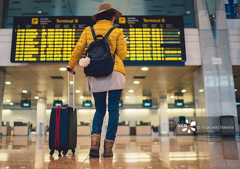 在巴塞罗那机场查看到达出发信息板的游客图片素材