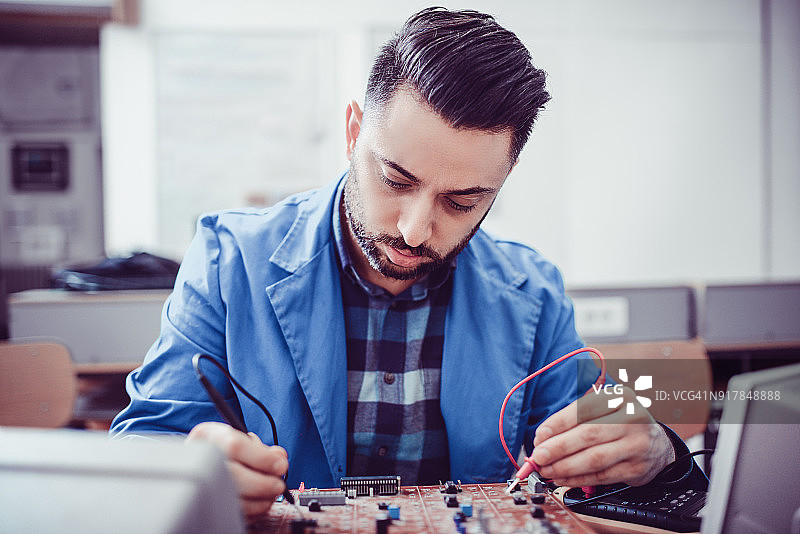 在办公室测量的年轻英俊的工程师图片素材