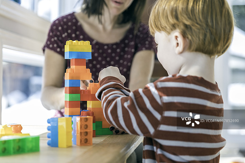 母亲和男婴玩彩色积木图片素材