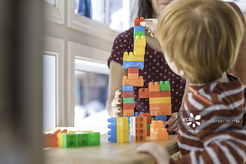 母亲和男婴玩彩色积木图片素材