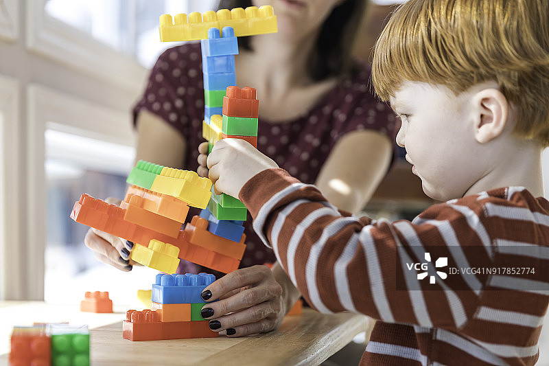 母亲和男婴玩彩色积木图片素材