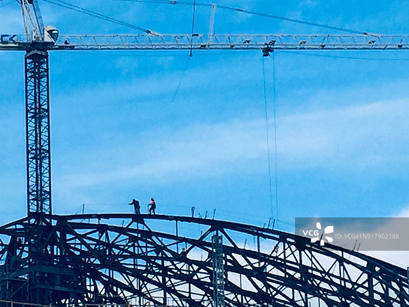 建筑起重机，钢铁工人们正在建造一个新的竞技场图片素材