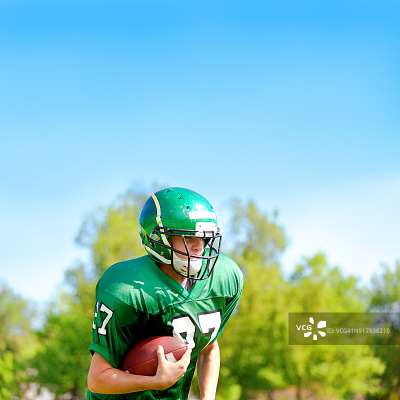 在球场上比赛的美国高中或大学橄榄球运动员图片素材
