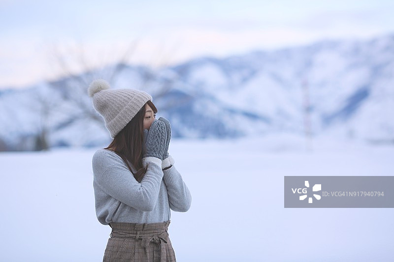 在雪地里观看东西的年轻女人图片素材