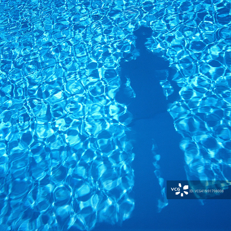 站在游泳池边的人的倒影图片素材