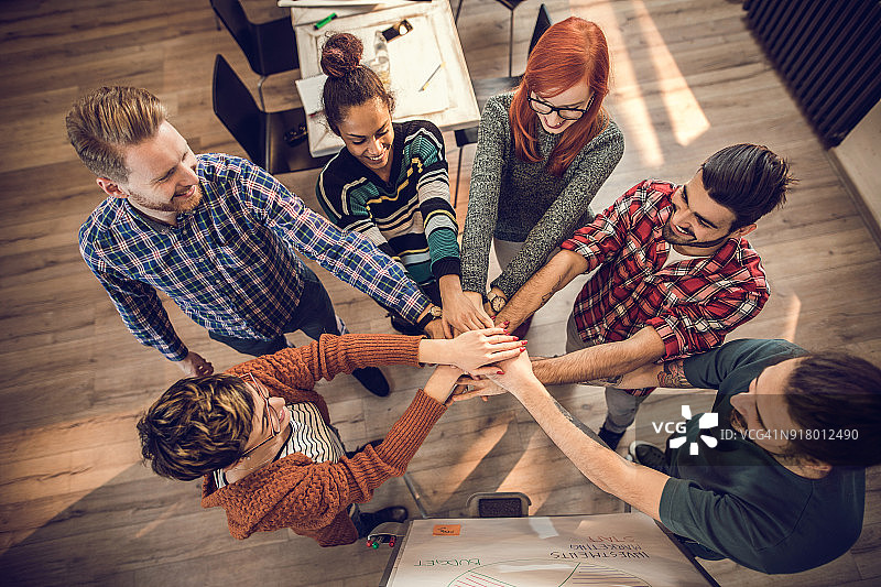 快乐的创业团队手拉手团结一致（俯视）图片素材