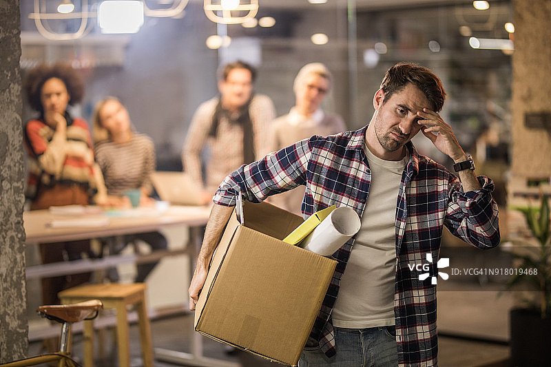 沮丧的企业家被解雇后离开办公室图片素材