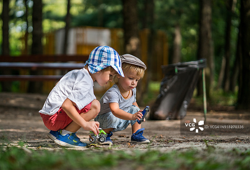 小兄弟在户外玩汽车玩具图片素材