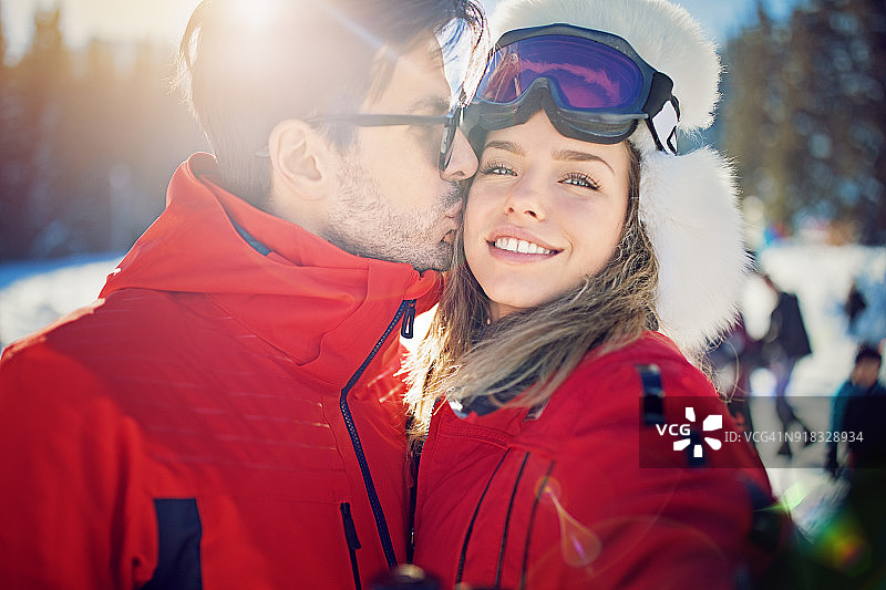 年轻夫妇在滑雪坡上自拍/进行视频通话图片素材