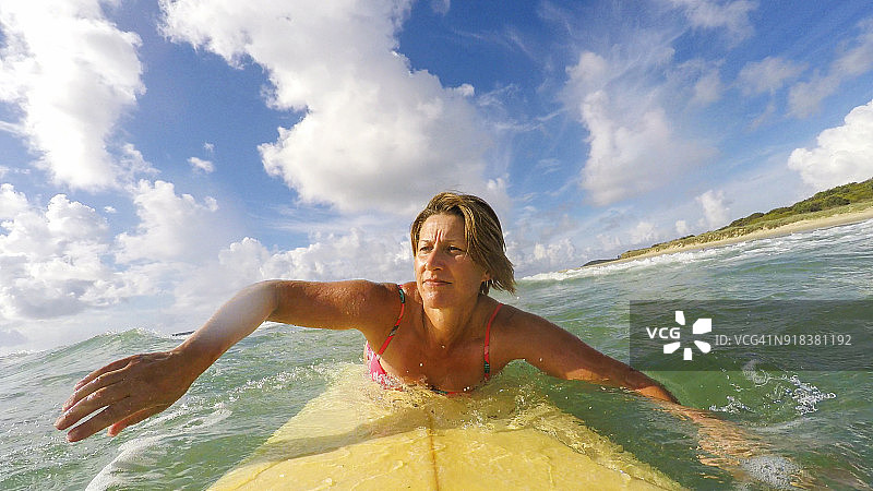 POV视角：中年妇女在海滩冲浪图片素材