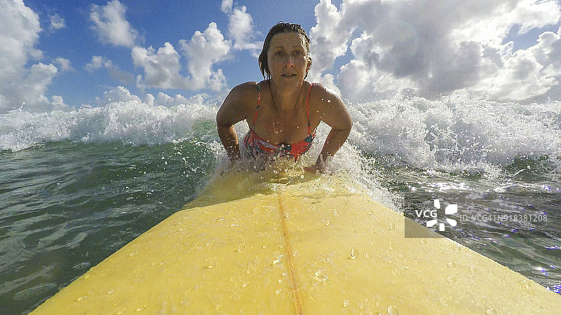POV视角：中年妇女在海滩冲浪图片素材