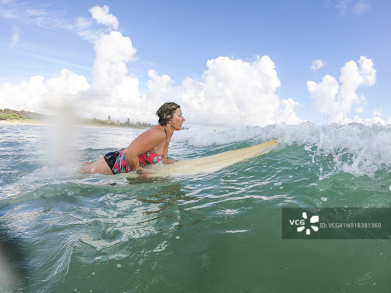在海滩冲浪的中年妇女图片素材