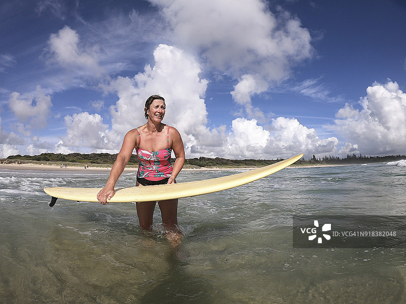 在海滩冲浪的中年妇女图片素材
