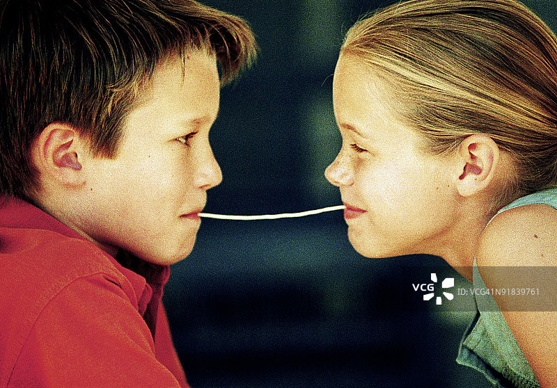 男孩和女孩嘴里含着意大利面图片素材