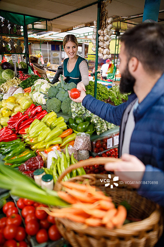 年轻人在农贸市场摊位购买蔬菜图片素材