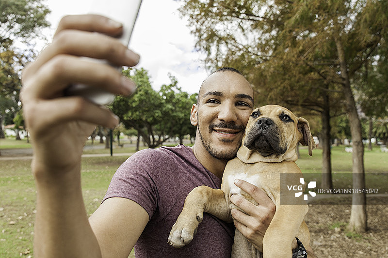 年轻男人抱着小狗自拍图片素材