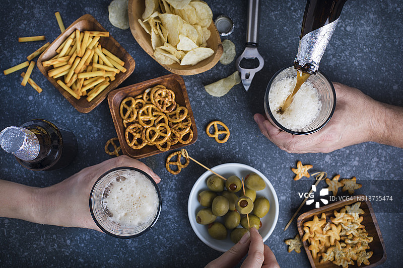 情侣餐桌上手持啤酒碰杯图片素材