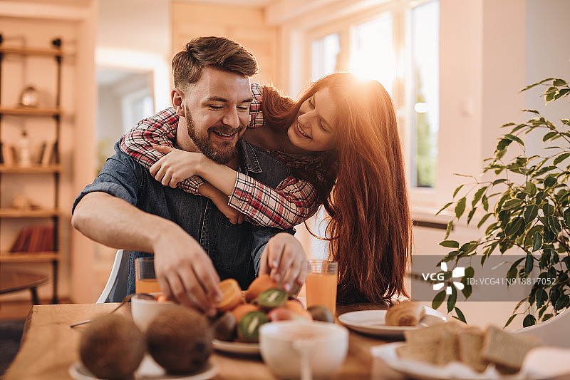 在家用餐时玩得开心的亲密情侣图片素材
