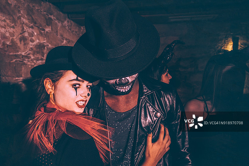 在夜总会派对上进行万圣节伪装的各民族夫妇图片素材