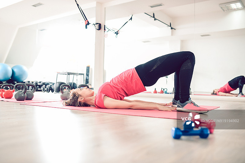 年轻女人健身房瑜伽后弯腹肌练习图片素材