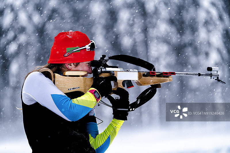 暴风雪中练习射击的女子冬季两项运动员侧面图片素材