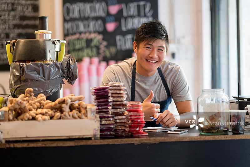 在健康食品店工作的亚洲男店员对着镜头竖起大拇指微笑图片素材