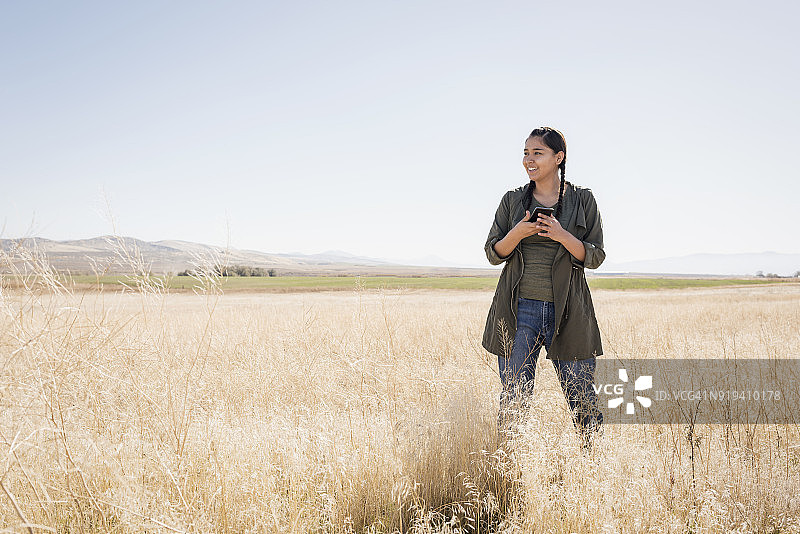 在户外使用手机的年轻美洲原住民妇女图片素材
