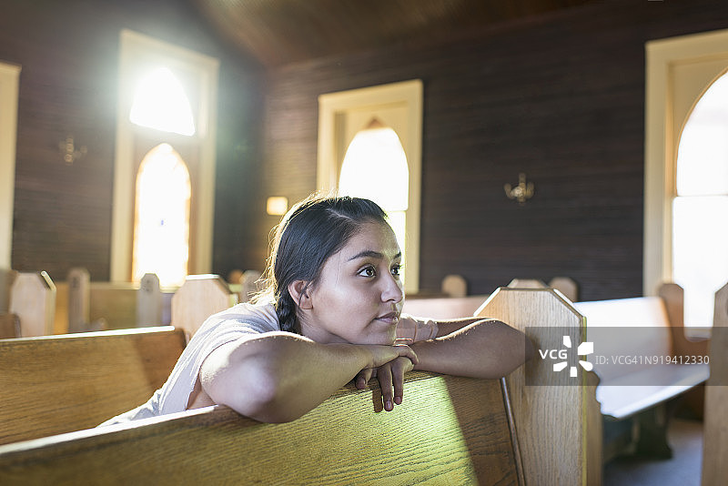 坐在教堂长椅上的年轻美洲原住民妇女图片素材