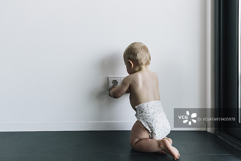 婴儿触摸未固定的电源插座图片素材