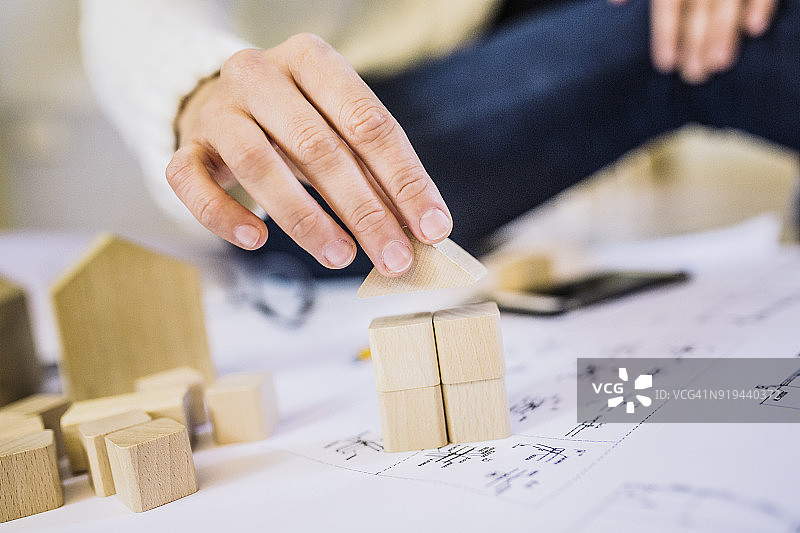 女人在蓝图上放置积木房子图片素材