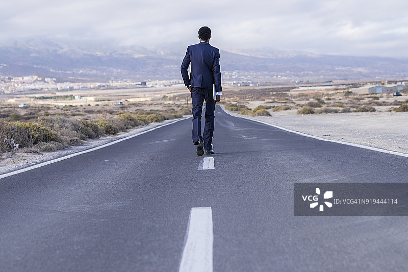 西班牙特内里费岛：携带笔记本电脑在路上行走的年轻商人图片素材