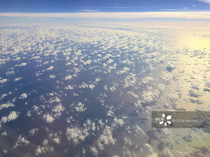 蓝色水面上方的浅白色云朵图片素材