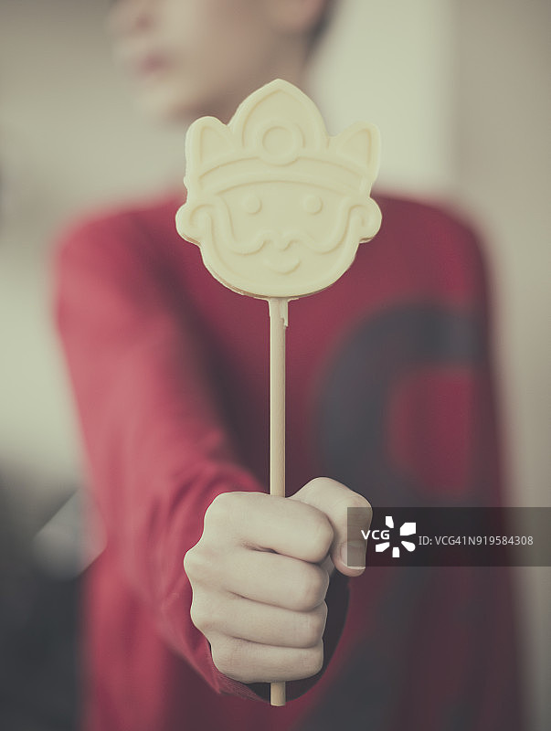 男孩拿着白色巧克力棒棒糖图片素材