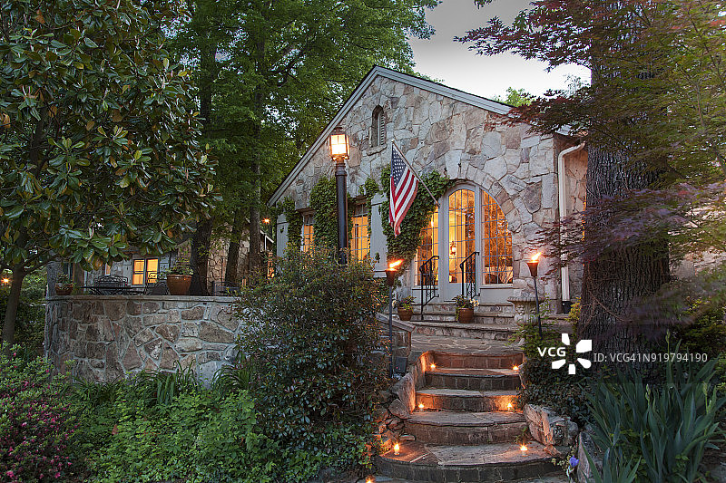 夏季花园环绕的夜间石屋外观图片素材