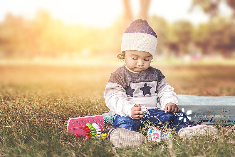 女婴在户外玩彩色积木图片素材