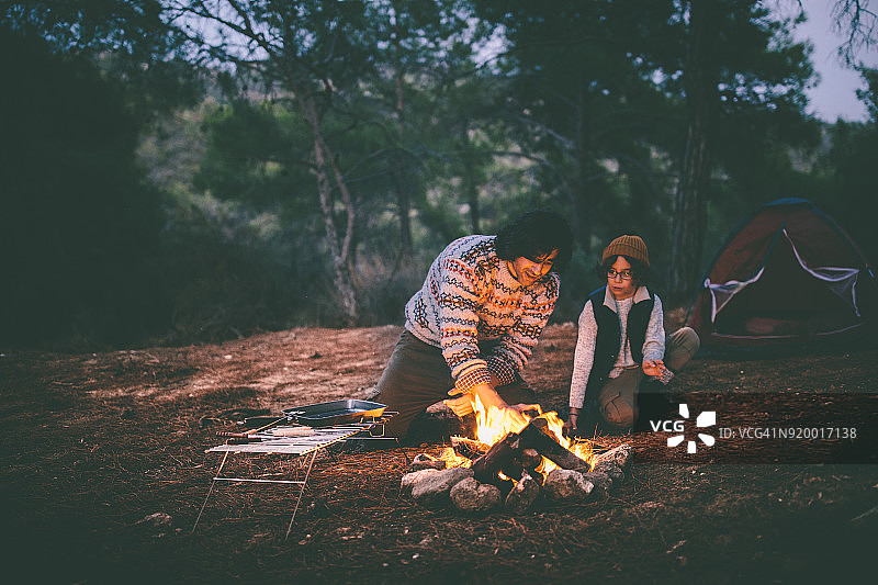 父子在树林里露营并点燃篝火图片素材