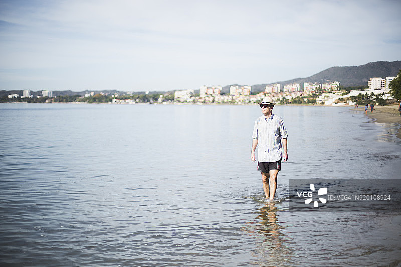 中年男人在沙滩上散步图片素材