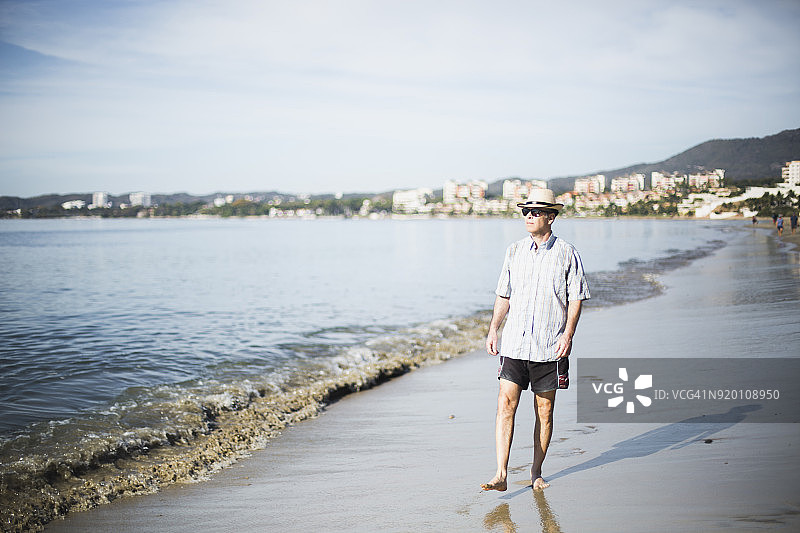 中年男人在沙滩上散步图片素材