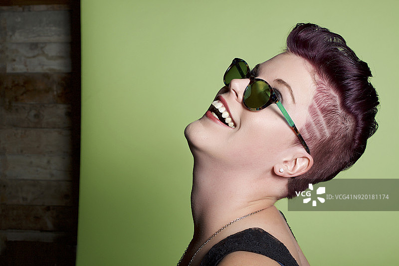 戴太阳镜的短发女人抬头大笑图片素材