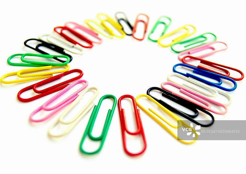 白色背景中排列成圆圈的彩色办公夹图片素材
