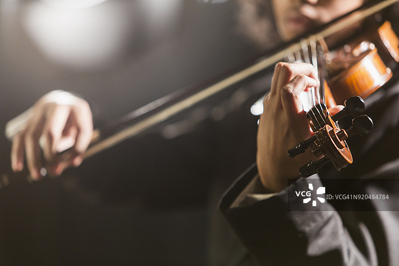 混血青少年男孩拉小提琴图片素材