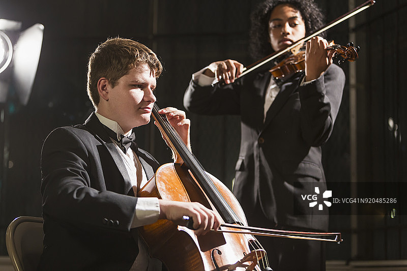 青少年男孩在音乐会上演奏低音提琴和小提琴图片素材