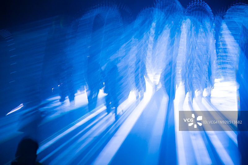 蓝色灯光下夜晚行走的人群剪影图片素材