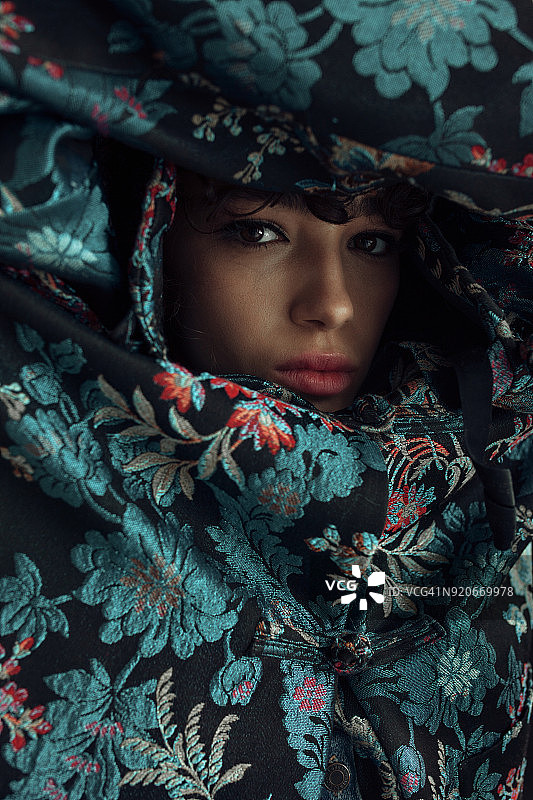 被蓝色花朵环绕的年轻女子面容图片素材