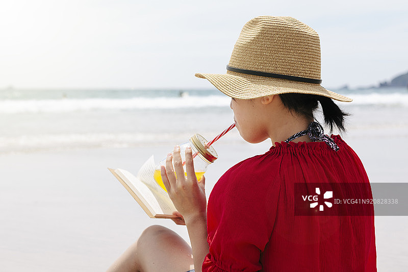 女人在海滩读书图片素材