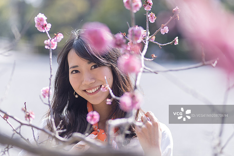 手拿梅花的年轻女人肖像图片素材